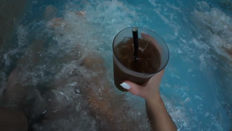 Couple-relaxing-at-spa-jacuzzi-with-dark-cola-drink-in-hand-relaxation-centre