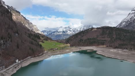 Klöntalersee's-tranquil-waters-with-Glärnisch-backdrop,-Switzerland-aerial