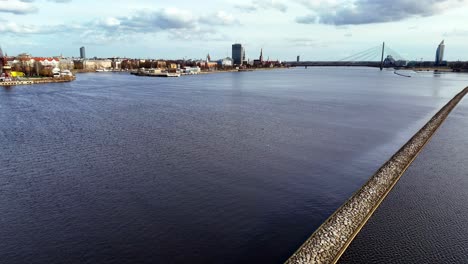 Vista-Aérea-Del-Río-Daugava-Con-Un-Muelle-De-Hormigón,-Riga,-Letonia
