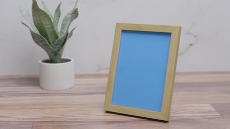 Picture-frame-with-replaceable-blue-screen-on-countertop-with-white-background-|-4K