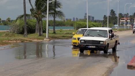 Floods-in-Varadero,-Cuba,-deep-water-puddles-and-cars-driving-slowly-and-carefully