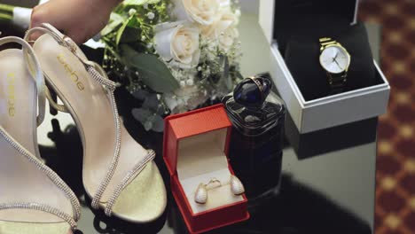 Close-up-of-a-woman's-hands-arranging-bridal-accessories-to-take-a-photograph