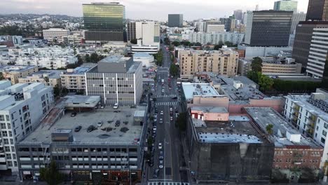 Push-in-drone-shot-with-bird's-eye-view-of-building-roof-tops-and-cityscapes-in-the-distance