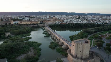 Luftaufnahme-Der-Römischen-Brücke-Und-Der-Moschee-Kathedrale-In-Córdoba,-Spanien-Während-Der-Blauen-Stunde