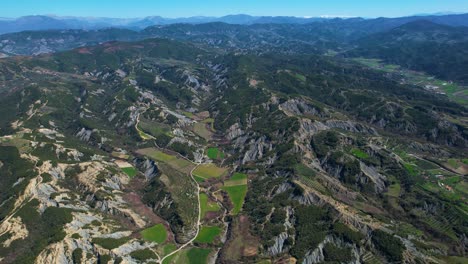 Ländliche-Landschaft-Mit-Sanften-Hügeln-Bis-Zum-Horizont-Und-Charmanten-Bergdorf-Inmitten-Grüner-Landwirtschaftlicher-Flächen-In-Albanien