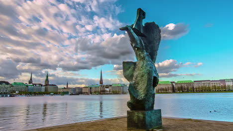 Time-lapse-of-the-Die-Windsbraut-statue,-clouds-moving-over-the-Hamburg-skyline