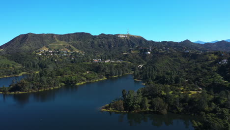 Aerial-tracking-shot-of-Lake-Hollywood-with-the-sign-in-the-background,-in-LA