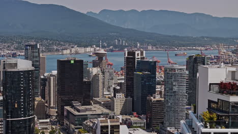 Vancouver-BC-Canada-Aerial-v116-zoomed-shot-drone-flyover-the-metropolitan-area-capturing-downtown-cityscape-against-harbour,-shipyard-and-North-mountain-views---Shot-with-Mavic-3-Pro-Cine---July-2023