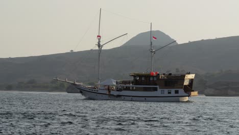 Barco-Turístico-Navega-Por-El-Mar-Con-El-Telón-De-Fondo-De-Una-Montaña-En-La-Isla-De-Komodo
