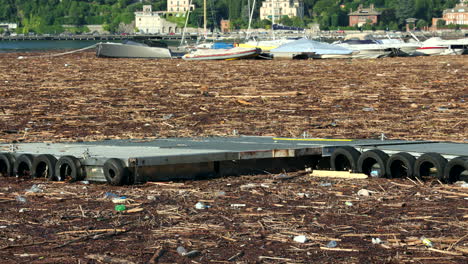 Como,-Italien---29.-Juli-2021---Hafen-In-Como,-Der-See-War-Nach-Schweren-Regenfällen,-Die-In-Der-Gegend-Schwere-Schäden-Verursachten,-Mit-Holz-Und-Schutt-Bedeckt