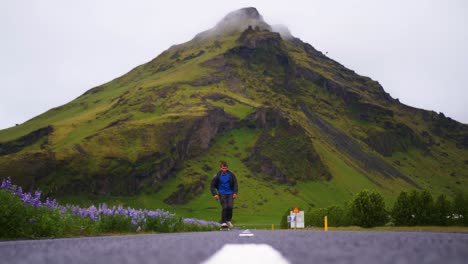 Skateboarder-does-a-trick-in-Iceland-with-beautiful-mountains-in-the-background
