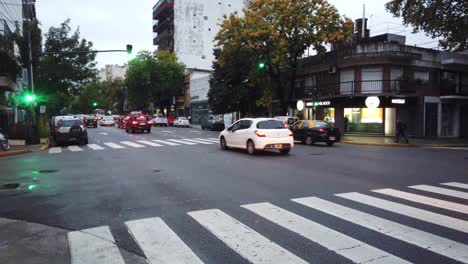 Los-Autos-Circulan-Por-La-Avenida-Gaona,-Hito-Del-Barrio-De-Flores,-Ciudad-De-Buenos-Aires,-Noche,-Anochecer,-Semáforo-Verde