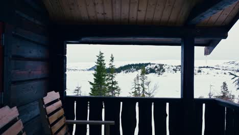 Terraza-De-Cabaña-De-Madera-Con-Vistas-Al-Paisaje-Blanco-Durante-El-Invierno.