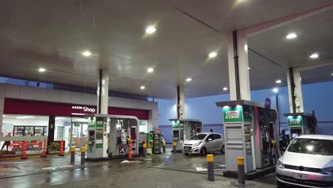 Gas-station-at-magenta-colorful-recharging-oil-store-Axion-cars-workers-lighting-shop-at-buenos-aires-city-latin-south-america,-argentina-at-night-nighttime