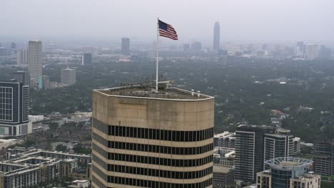 Drohnenansicht-Der-Amerikanischen-Flagge,-Die-Auf-Dem-Dach-Eines-Wolkenkratzers-In-Houston-Weht