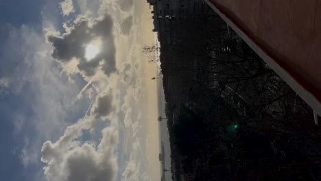 Sunset-Behind-Clouds-of-Cars-City-and-Coast-in-Cascais-Portugal,-Vertical-Timelapse