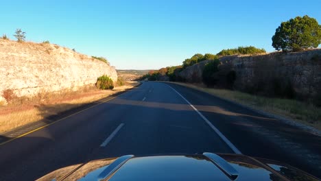 Car-drives-on-I10-steep-grade-near-Kerrville,-Texas,-USA,-POV-wide-shot