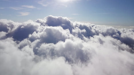 Aerial-view-over-high-cumulonimbus-clouds-on-a-sunny-day-under-a-blue-heaven