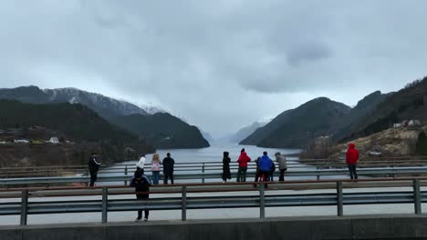 Los-Turistas-Admiran-La-Vista-Del-Fiordo-Hacia-El-Remoto-Fiordo-Veafjord-Desde-Un-Puente-Local.