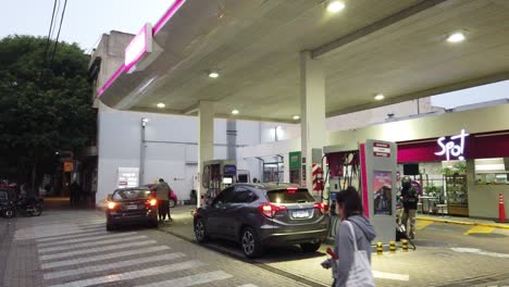 Coches-Cargando-Aceite-En-La-Gasolinera-Axion-Tienda-De-Conveniencia-En-La-Ciudad-De-Buenos-Aires-Noche-Argentina-Gente-Caminando-Y-Trabajando