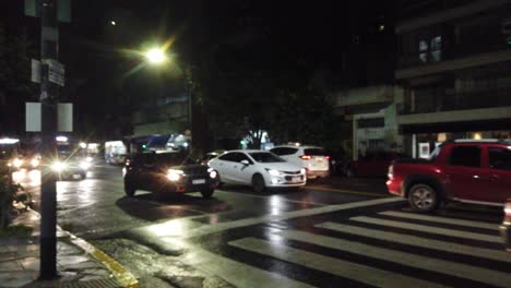 Nighttime-drive-buenos-aires-city-cars-buses-avenue-neighborhood,-rainy-weather