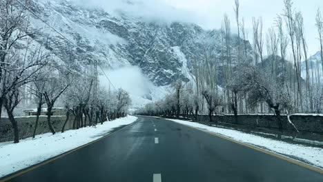 Coche-Conduciendo-Por-Una-Carretera-En-El-Paisaje-De-Skardu-Cubierto-De-Nieve---Está-Nublado