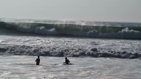 Silhouette-of-people-enjoys-massive-waves-of-Pacific-ocean-in-Los-Angeles