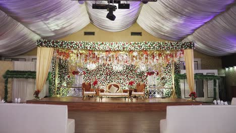The-stage-at-the-wedding-venue-is-adorned-with-colorful-flowers,-creating-a-beautiful-and-elegant-aesthetic