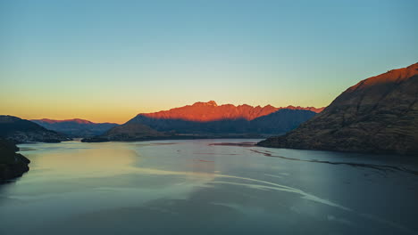 Sunset-over-Lake-Wakatipu,-New-Zealand-in-"The-Remarkables"-mountains---aerial-hyper-lapse