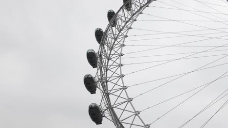 looking-up-at-a-skyward-perspective-capturing-the-The-London-Eye,-or-the-Millennium-Wheel,-against-the-backdrop-of-the-cloudy-London-sky-slowly-rotating