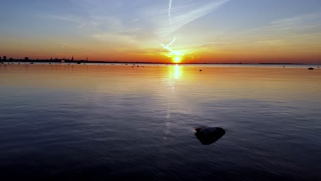 Estonia-Tallin-capital-city-during-sunset,-drone-fly-above-the-Baltic-Sea