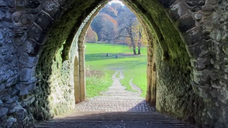 Two-individuals-sprint-through-the-historic-tunnel-in-a-city-centre-park