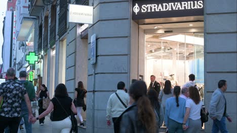 Buyers-and-pedestrians-walk-past-the-Spanish-women's-clothing-fashion-brand-from-Spain-owned-by-the-Inditex-group,-Stradivarius,-store-during-nighttime