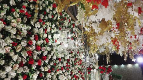 A-close-up-photo-of-the-stage-is-decorated-with-colorful-flowers-and-an-elegant-white-chandelier-suspended,-enhancing-its-overall-beauty