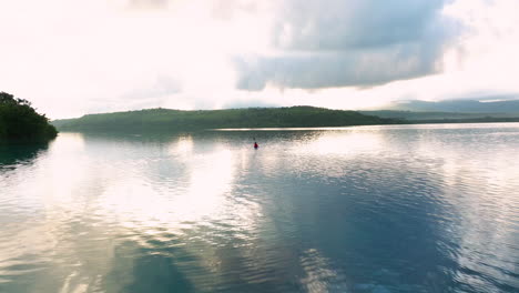 Pullback-Enthüllung-Eines-Männlichen-Touristen,-Der-Im-Morgengrauen-Auf-Dem-See-Auf-Der-Insel-Moso-In-Vanuatu-Kajak-Fährt
