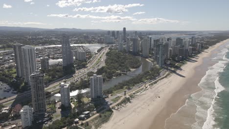 Embark-on-a-visual-journey-above-the-vibrant-Gold-Coast,-where-sandy-beaches-meet-the-towering-cityscape-in-stunning-drone-footage