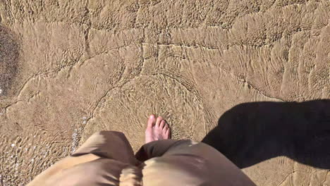 Kaukasische-Füße-Gehen-Und-Berühren-Das-Wasser-Am-Weißen-Sandstrand,-Selfie-Von-Oben-Nach-Unten,-POV