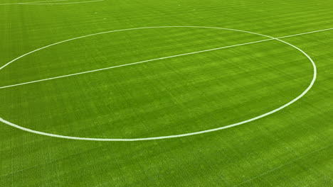 Aerial-Close-up-of-a-soccer-field's-central-circle-with-freshly-painted-white-boundary-lines-on-vibrant-green-grass---panorama-left-to-right