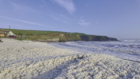 sea-foam-blowing-up-beach-at-Kilmurrin-in-Storm-Kathleen-On-the-Copper-Coast-Waterford-Ireland-natures-wonders