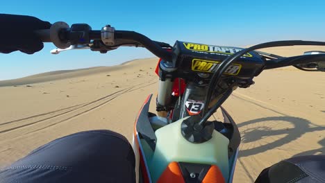 Hot-desert-sun,-riders-at-full-throttle-over-sandy-terrain