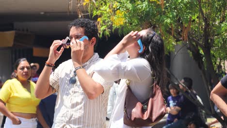 Pareja-Latina-Observando-El-Eclipse-Solar-Con-Gafas-De-Sol-De-Cartón,-México-8-De-Abril-De-2024