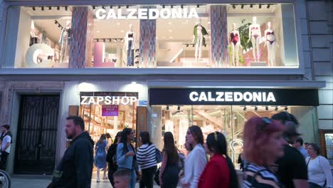 Shoppers-and-pedestrians-walk-past-the-Italian-fashion-legwear,-socks,-and-swimwear-brand,-Calzedonia,-store