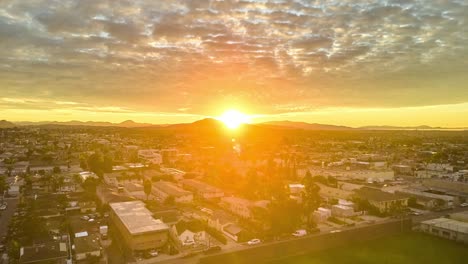 Forward-flying-drone-flight-heading-into-the-sun-with-active-clouds-above-and-motion-over-the-ground-in-a-time-lapse-or-hyperlapse-capturing-the-sun-rising-over-the-eastern-hills