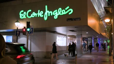 Se-Ven-Peatones-Afuera-De-Los-Grandes-Almacenes-Más-Grandes-De-España,-El-Corte-Inglés,-Durante-La-Noche.