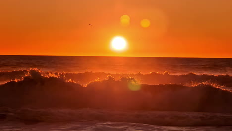 Olas-En-Cámara-Lenta-Bajo-El-Atardecer-Rojo-En-Una-Playa-Serena