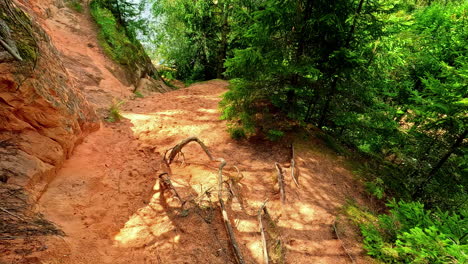 Spaziergang-Auf-Einem-Erdpfad,-Einer-Landschaft-Mit-Klippen-Und-Felsen,-Erglu-Klippen,-Klintis,-Lettland,-Ego-Perspektive-Aufnahme-Um-Bäume-Herum,-Wanderhügel-Im-Gauja-Nationalpark