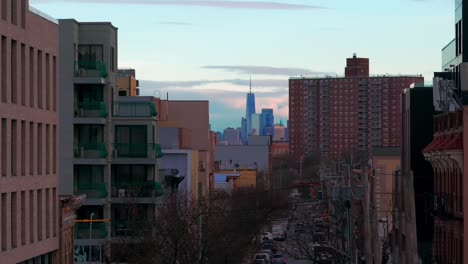 An-aerial-view-of-the-World-Trade-Center-in-the-distance,-seen-between-buildings-from-over-a-street-in-Coney-Island,-Brooklyn-on-a-cloudy-day