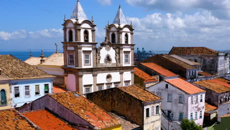 Vista-Aérea-De-Las-Casas-En-El-Barrio-De-Pelourinho-Y-El-Mar-Al-Fondo,-Salvador,-Bahía,-Brasil.