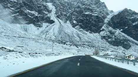 Car-driving-on-a-road-in-Skardu-in-landscape-covered-with-snow-and-high-mountains