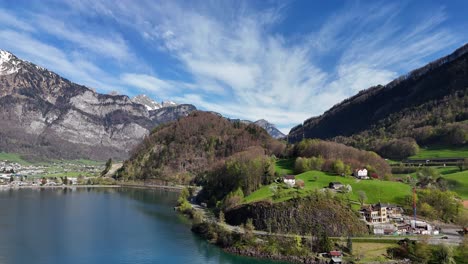 Aerial-rising-shot-of-houses-on-idyllic-hills-near-Lake-Walen-in-summer